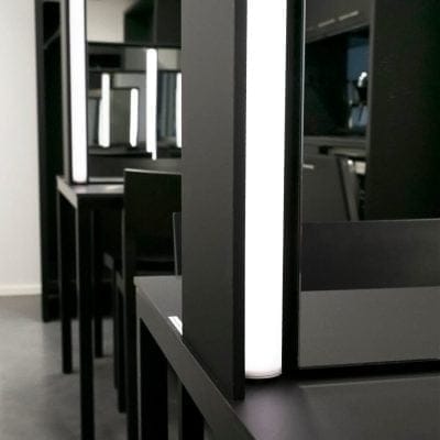 Lähikuva tyylikkäästä, modernista salonkisisustuksesta, jossa on mustakehyksiset peilit ja korkeat LED-valaistuspaneelit. Design on minimalistinen, selkeälinjainen ja hienostuneen nykyaikainen – täydellinen esimerkki LedStore.fi:n tarjoamasta led-valaistusratkaisusta kotisi sisustukseen.