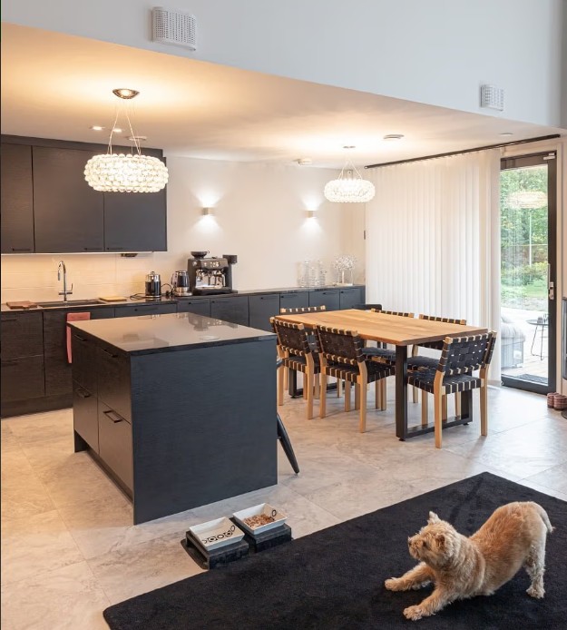 Modernes Design, modernes Design, moderne LED-Beleuchtung, modernes Design, modernes Design, modernes Design. - LedStore Moderni keittiö ja ruokailutila, joissa on mustat kaapistot, puinen ruokapöytä sekä mukava LedStore.fi:n led-valaistus luovat viihtyisän tunnelman. Mustalla matolla venyttelevä kissa tarkkaee kodikkaan kokonaisuuden.