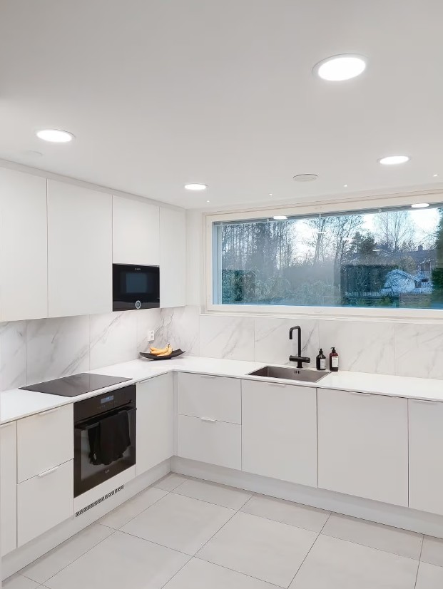 Modernes Design, modernes Design, marmoriertes Öl, langlebiges Design und integriertes Design – LED-Beleuchtung mit LED-Beleuchtung. - LedStore Paneelivalot keittiön katossa, led-nauhavalot kaapiston alapinnassa sekä pienet korostusspotit ikkunan edessä riviin aseteltuna.