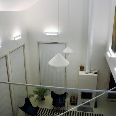 Olohuoneeseen luotu tunnelmallinen epäsuora valaistus Led BLADE seinävalaisimilla. Valaisin on asennettu valaisemaan alhaalta ylöspäin ja näin epäsuora valaistus myös korostaa tilan korkeutta sekä taideteosta seinällä. Ledstore.fi