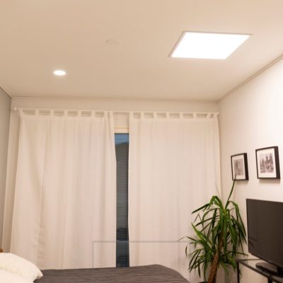 Makuuhuoneessa plafondit ja paneeli valaisemassa tilaa tasaisesti ja laadukkaasti. Iso paneelivalaisin muistuttaa kattoikkunaa. Ledstore.fi 