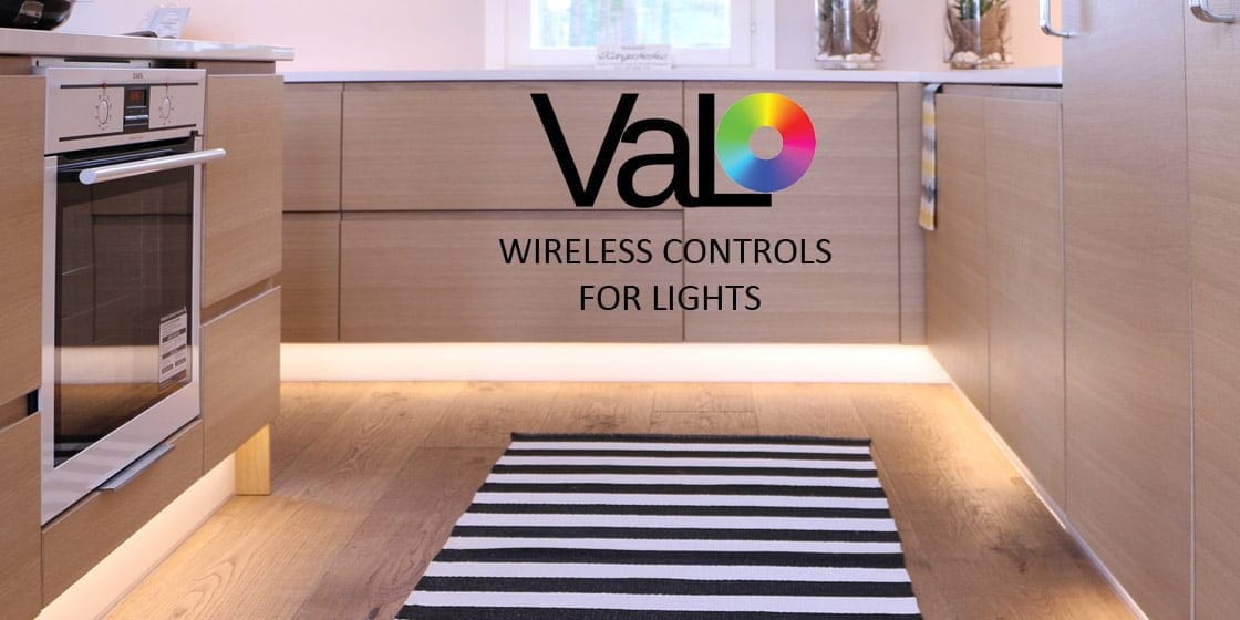 Modern kitchen with wooden cabinets, oven, striped black and white rug, and "VaLO: Wireless Controls for LED Lights" logo overlay.